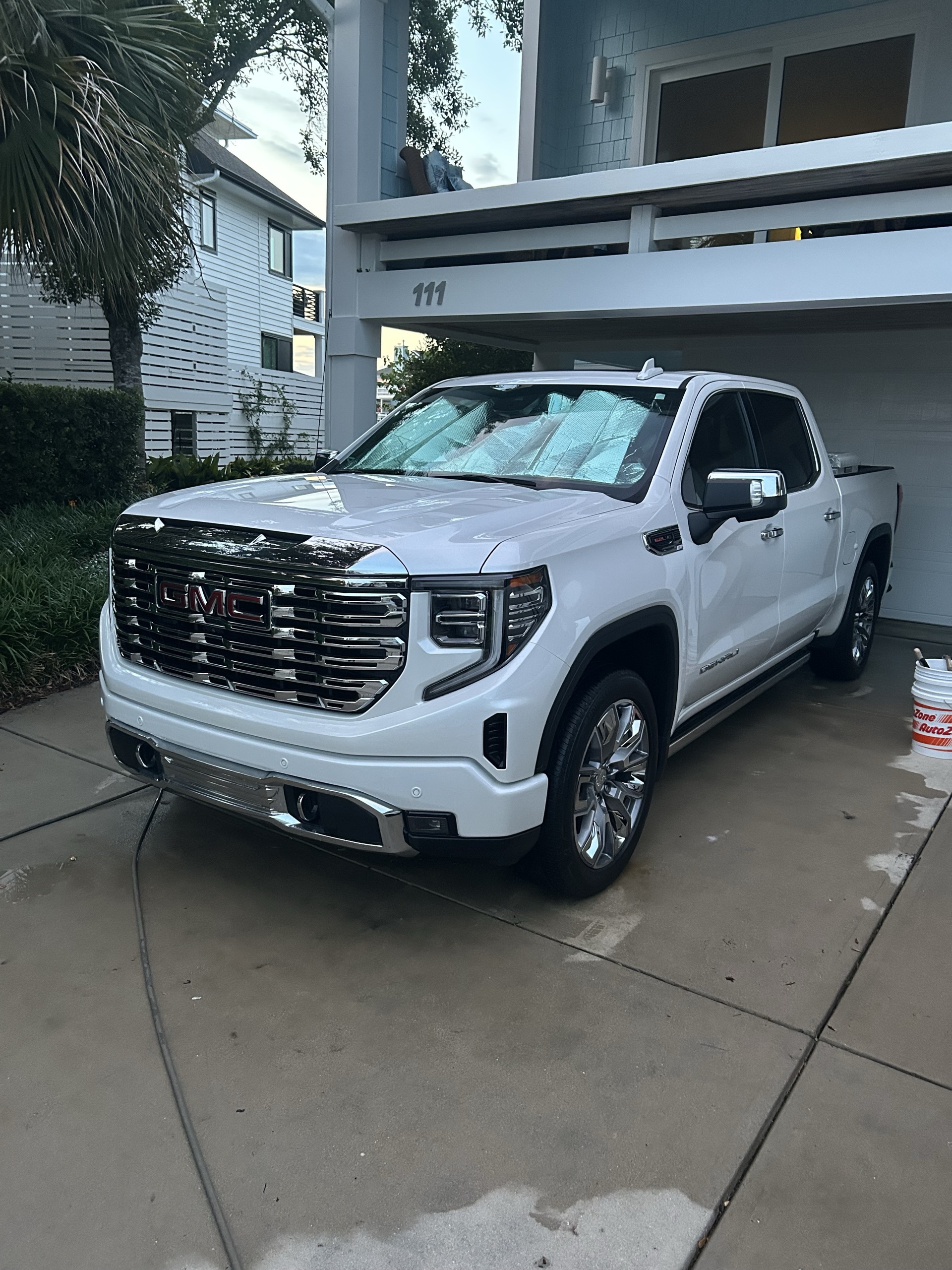 Freshly polished white GMC Sierra Denali with a deep, glossy finish