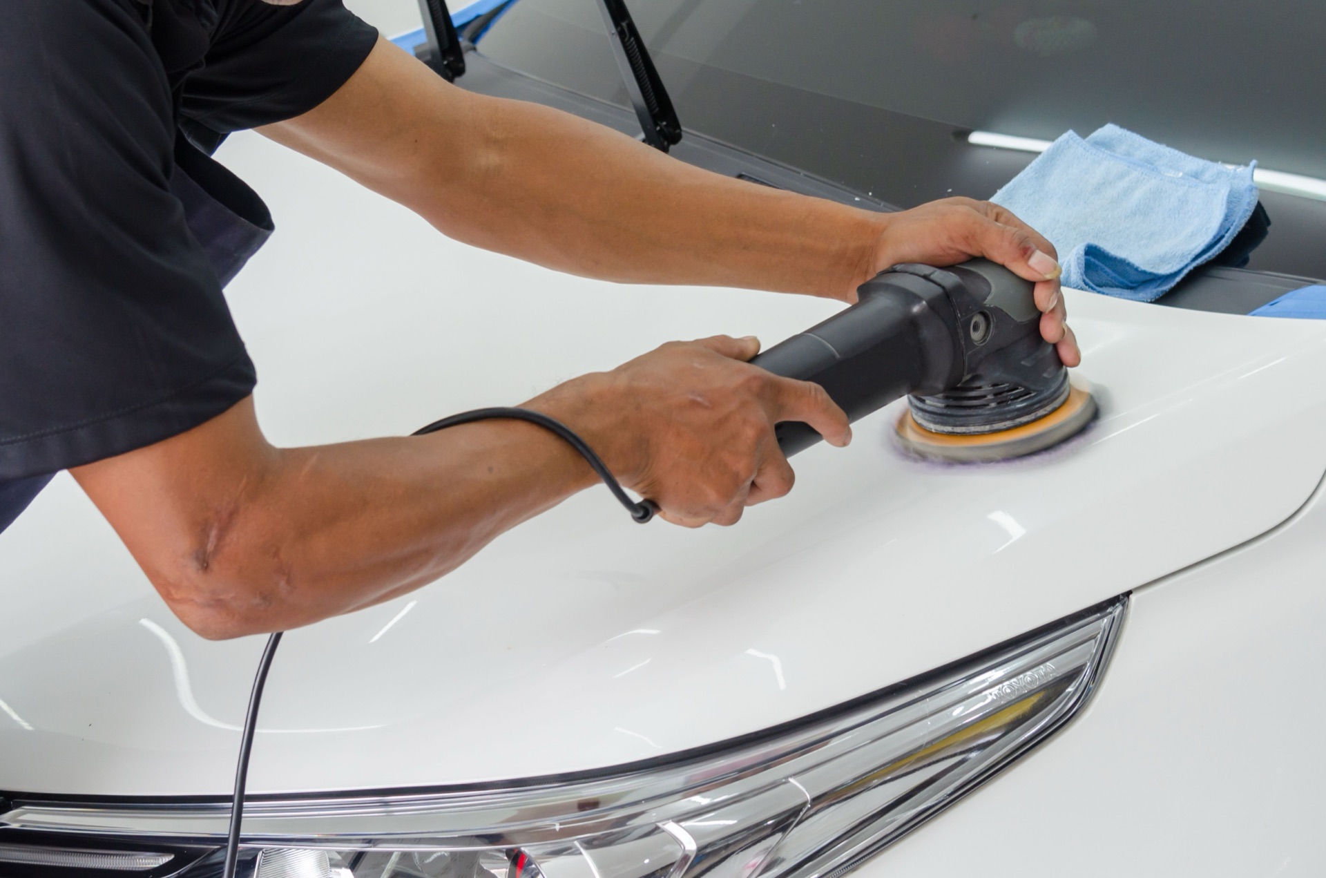 Technician using a dual-action polisher for paint correction